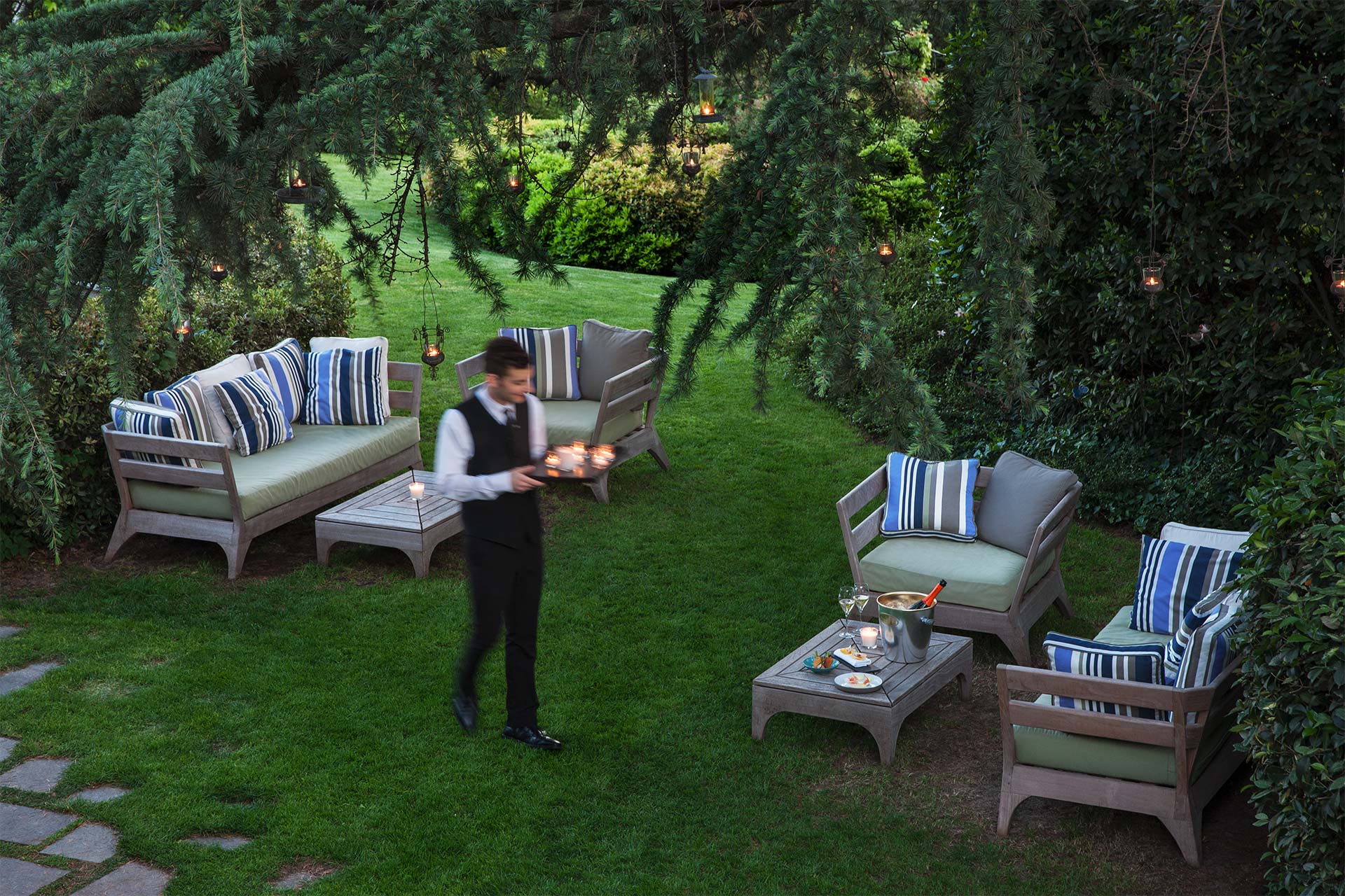 A person carrying a tray in L’Albereta’s garden