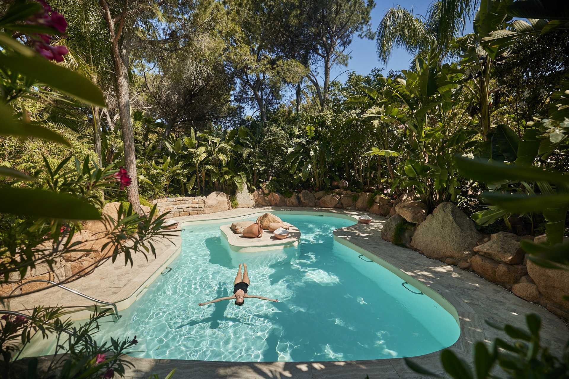 A guest floating in an Acquaforte garden pool at Forte Village